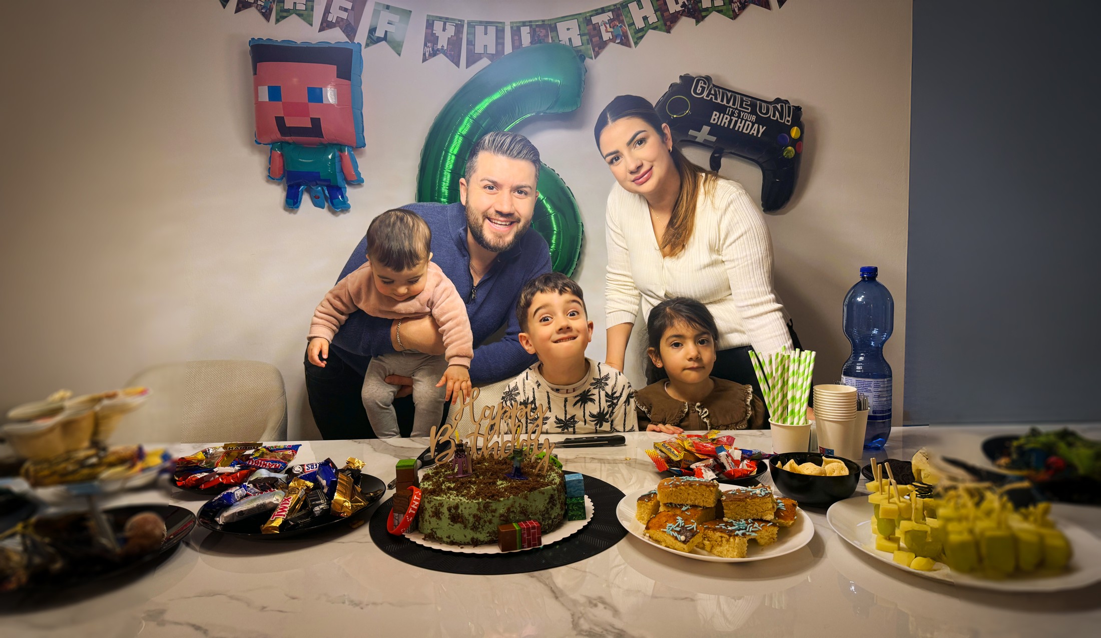 Sobia und Selim mit ihren drei Kindern an einem festlich gedeckten Geburtstagstisch